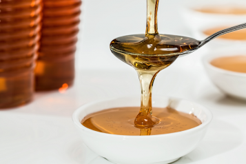 Pouring honey onto a teaspoon 