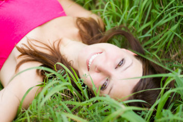 A woman laying down in a grass field