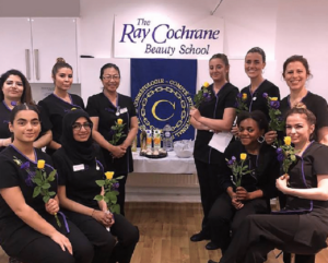 Ten people with flowers in the Ray Cochrane Beauty School