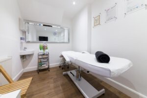 Beauty Therapy salon room with a bed and mirror 