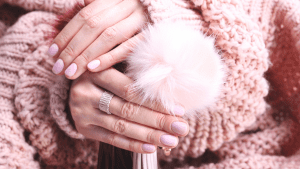 Two hands with pink nails and pink jumper