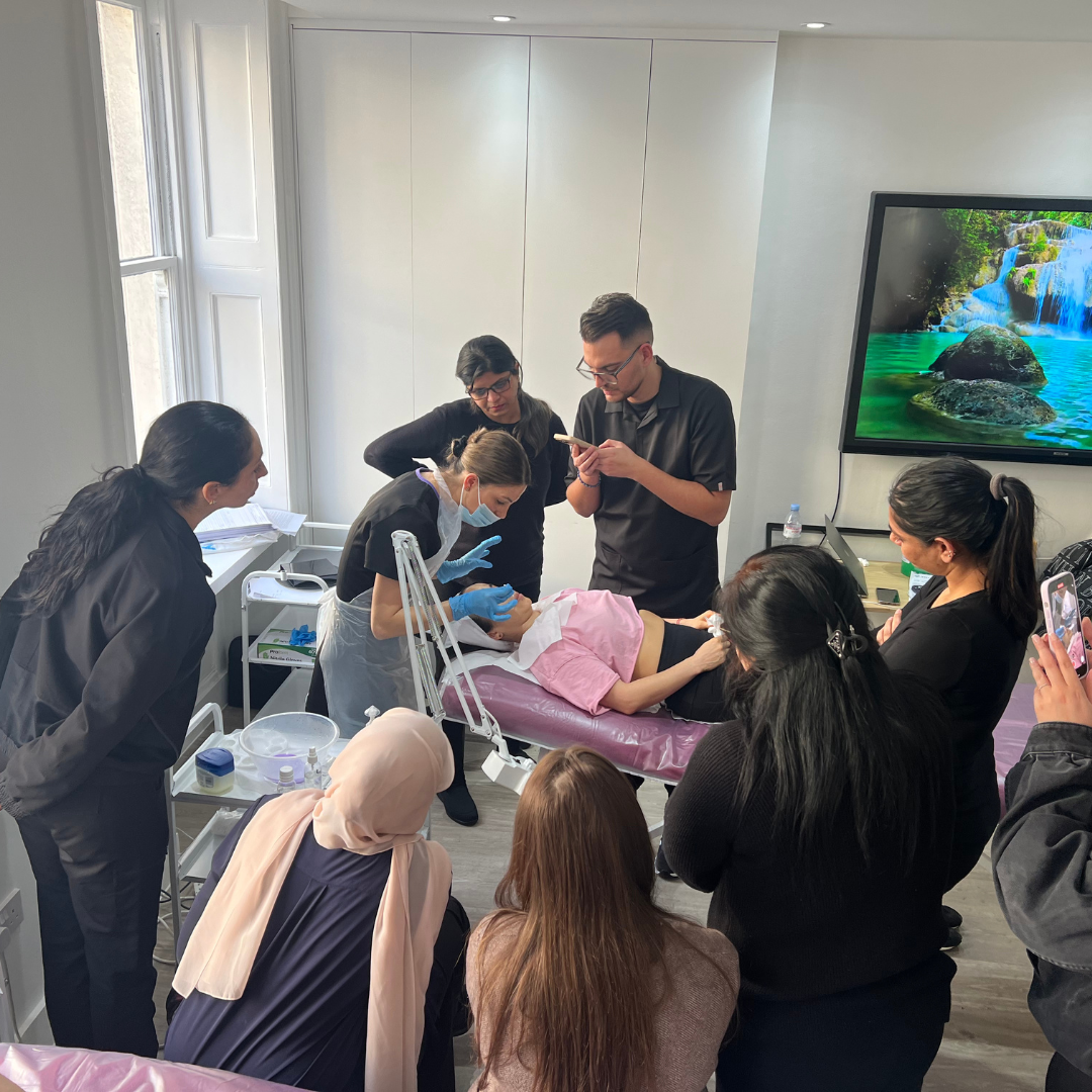Students observing a chemical skin peel demonstration in the Ray Cochrane classroom
